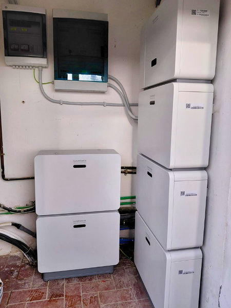 Foto di un'installazione reale di un sistema di accumulo SunPower con sei moduli batteria bianchi disposti su due colonne in un locale tecnico domestico