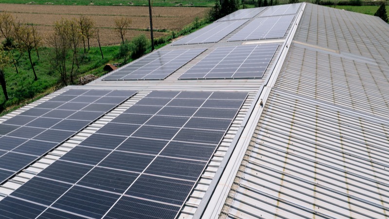 Veduta aerea di pannelli fotovoltaici modernizzati con intervento di reevamping su tetto industriale.