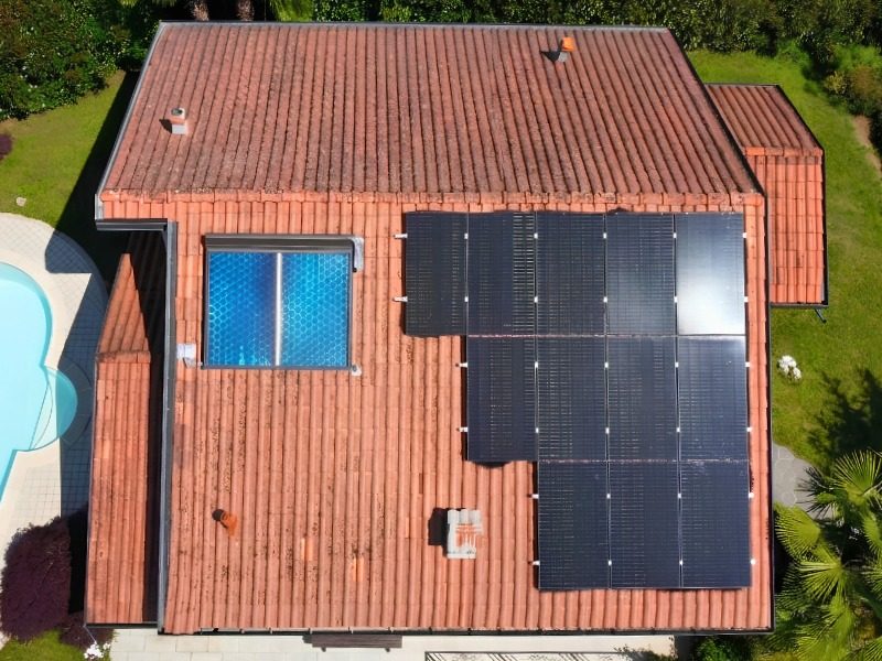 Visuale aerea di un tetto con installazione di pannelli fotovoltaici e un pannello solare termico
